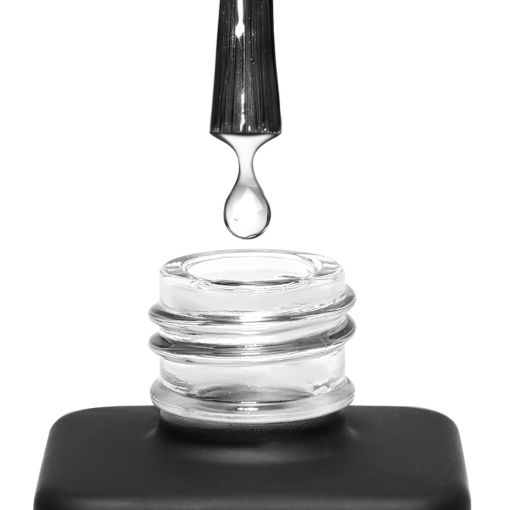 Klarer Nagellack tropft in offene Glasflasche