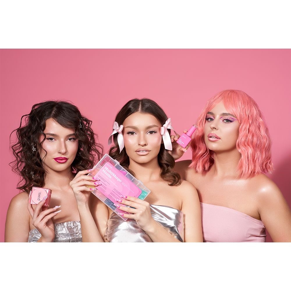 Drei Frauen präsentieren verschiedene pinke Haarpflegeprodukte vor einem pinken Hintergrund.