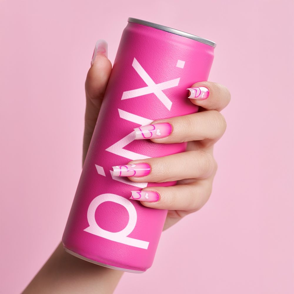 Hand mit pinker Dose und kreativem Nageldesign in Rosa und Weiß